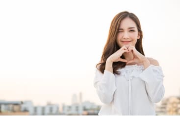 手すりにもたれている美しい女性が笑いかけている